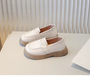 Gedetailleerd zijaanzicht van stijlvolle crème loafers voor kinderen in Britse stijl met zool