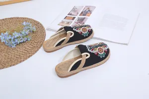 Close-up detail of ethnic style black embroidered slippers with hand-woven rope sole
