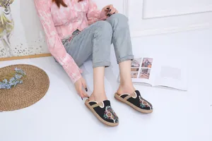 Close-up view of ethnic style black embroidered slippers with handmade straw soles