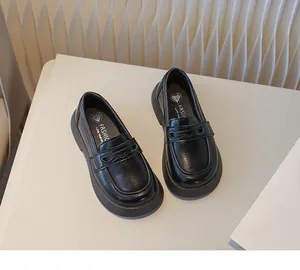 Gedetailleerd bovenaanzicht van klassieke zwarte loafers in Britse stijl voor kinderen.