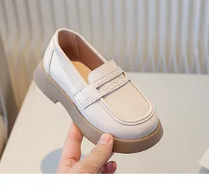 Detail van het zijaanzicht van een crème Britse stijl leren loafer voor kinderen