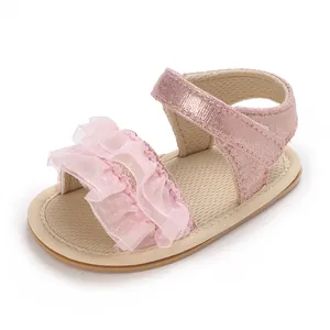 Primo piano di graziosi sandali rosa per neonata con volant in pizzo e cinturino glitterato.