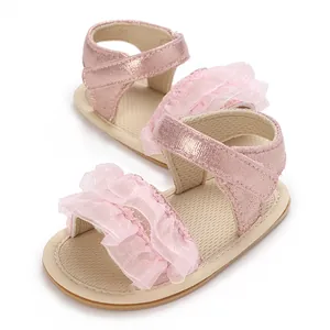 Primo piano di sandali rosa da principessa per neonata con pizzo a balze e cinturini lucidi