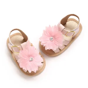 Vista detallada de sandalias rosas para niños pequeños con flor grande y diamantes