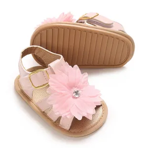Primer plano de sandalias rosas para bebé con una gran flor rosa y hebilla dorada