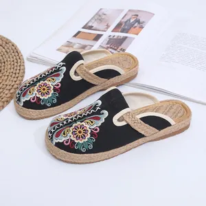 Ethnic style black slippers with floral embroidery and handmade woven jute soles for women.