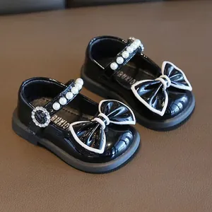 Elegante schwarze Baby-Prinzessinnenschuhe mit Perlenriemen und weiß umrandeten Schleifen