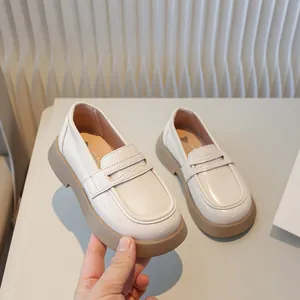 Klassieke Britse stijl kinderloafers in crème met duurzame bruine platte zolen.
