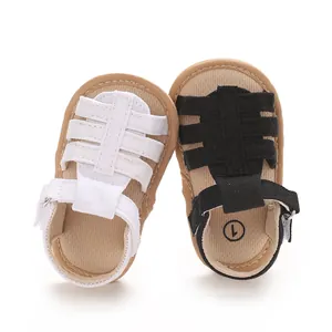 Vista dettagliata di sandali estivi per neonati in bianco e nero con suole morbide e velcro.