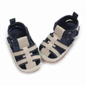 Primo piano di sandali per neonati blu scuro e beige con suole morbide per i primi passi