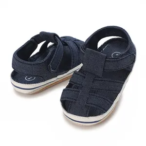 Dettaglio scarpe primi passi in denim blu navy per neonato con suola morbida e traspirante.