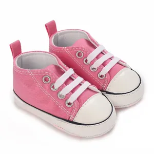 Detaillierte Nahaufnahme von weichen rosa hochgeschnittenen Babyschuhen aus Canvas