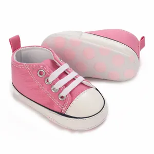 Nahaufnahme von rosa Baby-Canvas-Schuhen mit rutschfesten Sohlen im Polka-Dot-Design