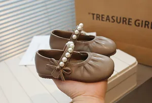 Close-up of girl's retro Mary Jane shoes featuring elegant pearl-beaded straps and bow detail