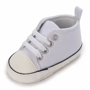 Hochwertige Nahaufnahme weißer Canvas-Babyschuhe mit Schnürsenkeln für Neugeborene