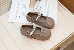 Close-up of retro children's Mary Jane shoes with pearl strap and bow detail