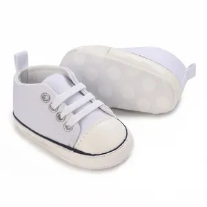 Detailansicht weißer hoher Baby-Leinenschuhe mit einer rutschfesten Polka-Dot-Sohle