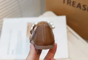 Close-up detail of the brown leather Mary Jane shoe heel with elegant pearl accents.