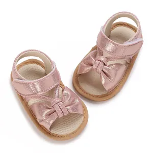 Detailed view of pink glittery baby girl sandals featuring elegant bow and soft sole