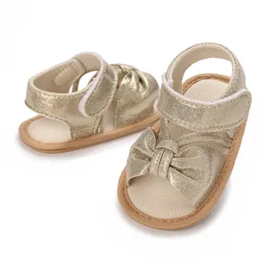 Detailed view of champagne gold baby girl sandals with bow and velcro strap