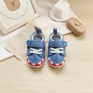 Detailed view of cute blue baby soft sole canvas walking shoes with shark teeth pattern.