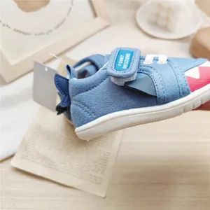 Detail of blue shark-themed baby walking shoe with soft sole and velcro strap