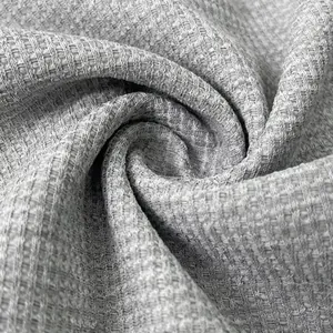 Dettaglio macro della trama di un tessuto grigio pesante in maglia a nido d'ape per uomo
