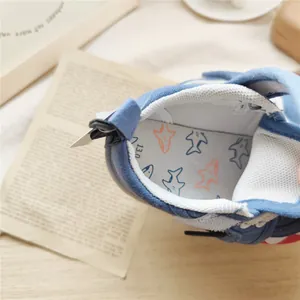 Close-up of blue baby soft-soled walking shoe interior featuring cute shark pattern insole