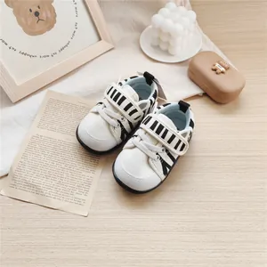 Detailed view of baby walking shoes with zebra pattern and cute ears on a warm background