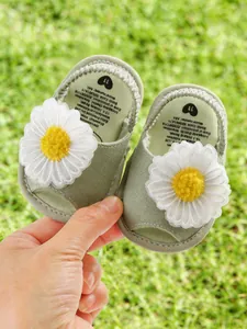 Sandales bébé vert sauge avec décoration fleur de marguerite blanche pour l'été