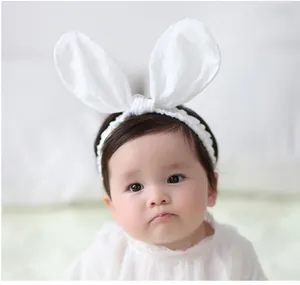 Adorable white baby headband with cute plush rabbit ears for newborn girls photo styling.