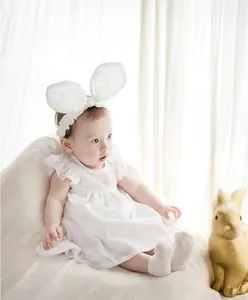 Soft white baby princess socks with non-slip sole detail worn by a baby girl model