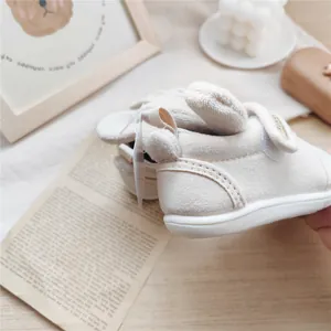 Detailed view of cream-colored baby soft sole walking shoes featuring cute plush rabbit ears