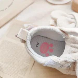Macro view of baby soft sole pre-walker shoe interior featuring a cute pink paw insole