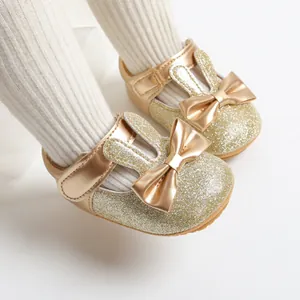 Close-up of sparkling golden baby princess walker shoes with bow and cute rabbit ears