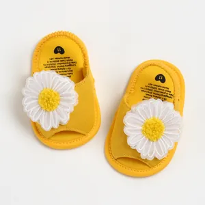 Vue détaillée de dessus de sandales jaunes pour bébé avec grandes marguerites blanches en tissu