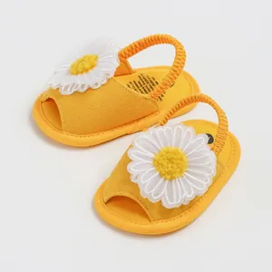Vue détaillée de sandales d'été jaunes pour bébé avec fleur de marguerite en maille