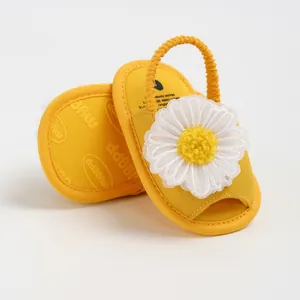 Gros plan sur des sandales jaunes pour bébé avec marguerite blanche et bride arrière élastique