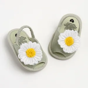 Détail de sandales pour bébé avec décoration de marguerite sur toile vert clair