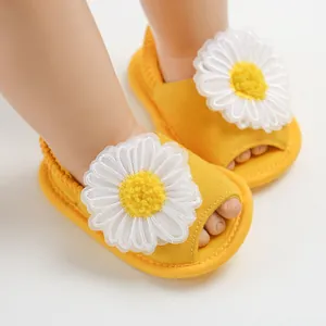 Vue détaillée de sandales jaunes pour bébé avec appliques de marguerites blanches