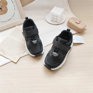 Detailed macro view of black breathable mesh kids' sneakers with velcro strap closure