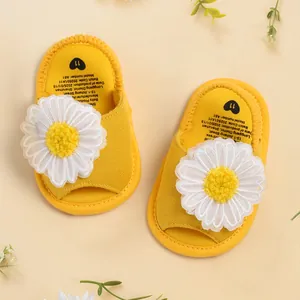 Gros plan détaillé de sandales jaunes pour bébé avec une grande marguerite tricotée