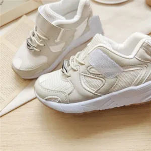 Close-up of cream children's functional sneakers featuring mesh and velcro strap details