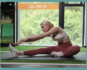 Close-up of woman in gym stretching wearing white breathable wading shoes on yoga mat