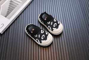 Dettaglio di scarpe in maglia per neonati leopardate con suole bianche flessibili