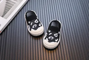 Dettaglio di scarpe in maglia per bambini con motivo leopardato e suole morbide