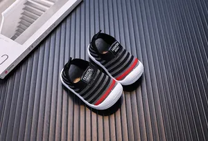 Professional top-down view of black and grey baby fly-woven sneakers with red accents