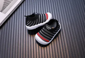 Close-up view of the breathable striped fly-knit texture and soft sole of baby walking shoes