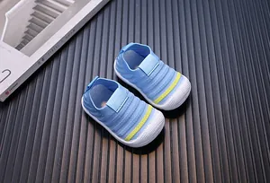 Detail of blue knit baby walking shoes with white rubber sole and yellow stripe detail