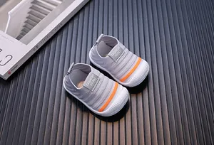 Detail shot of grey knitted baby walking shoes with orange stripes and mesh fabric